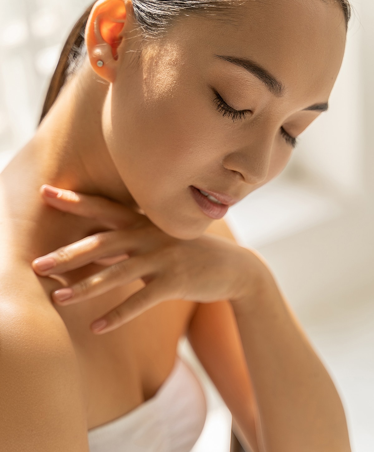Close-up of woman with serene expression and hand.